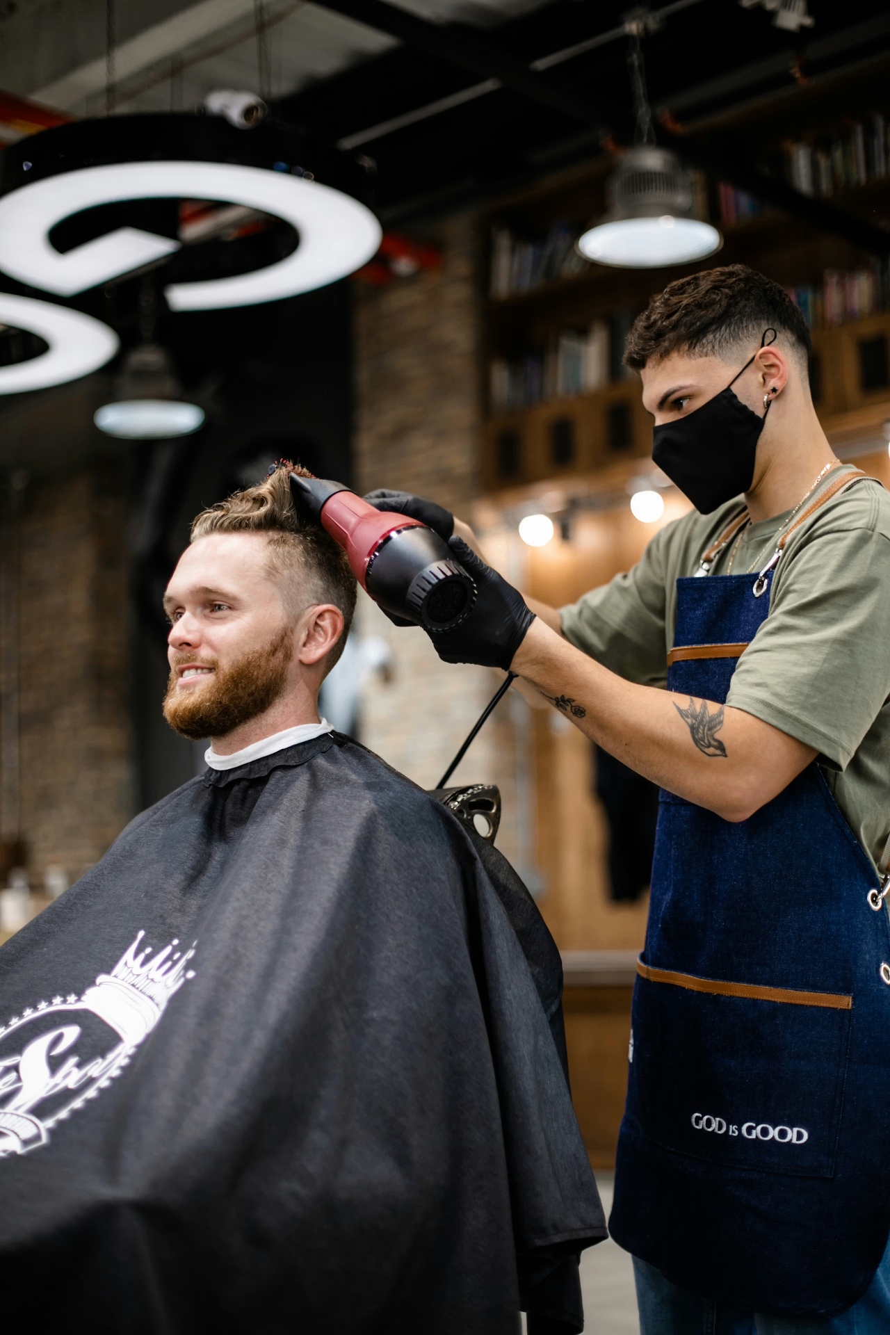 Barbeiro finalizando atendimento de um cliente em uma barbearia real